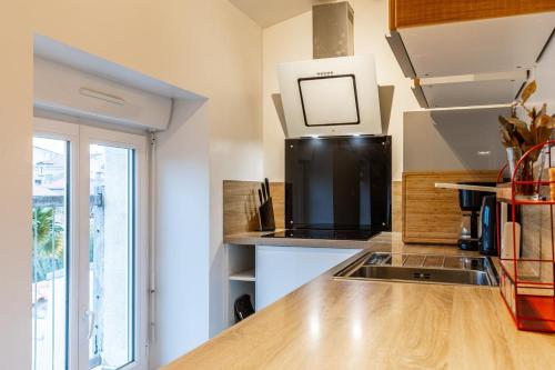 a kitchen with a sink and a microwave at GuestReady - Lovely Apt in The Heart of La Rochelle in La Rochelle