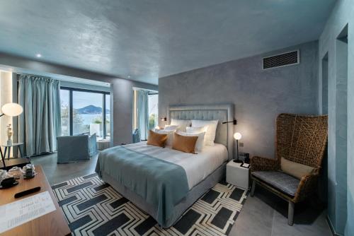 een slaapkamer met een bed en een stoel in een kamer bij Villa Geba Boutique Hotel in Sveti Stefan