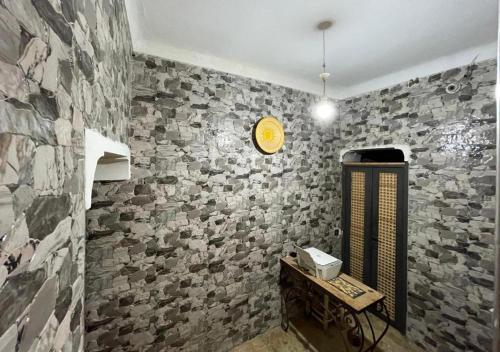 una stanza con un muro di pietra con un orologio sopra di Sun Hostel a Marrakech