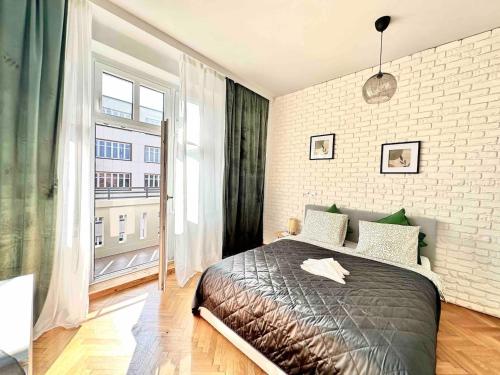 1 dormitorio con cama y ventana grande en Powstańców 22' Street Apartamenty i Pokoje en Katowice