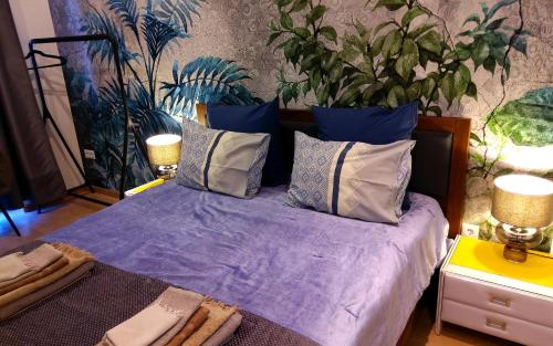 a bedroom with a bed with purple sheets and pillows at Bp Central Home in Budapest