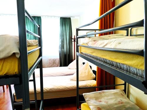 a room with three bunk beds and a window at Hostel Omega in Rzeszów