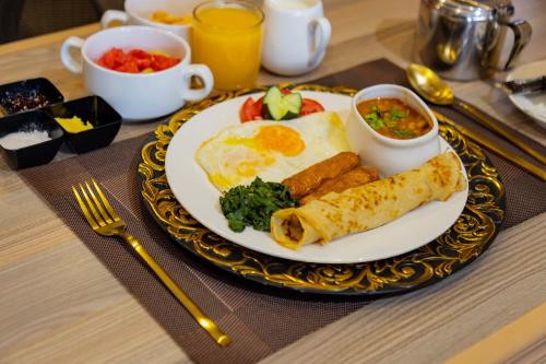 a plate of breakfast food with eggs and vegetables on a table at Raha Hotel & Suites in Nairobi