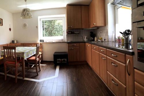 cocina con armarios de madera, mesa y ventana en Large 8 Bed Apartment. Perfect Location., en Stuhlfelden