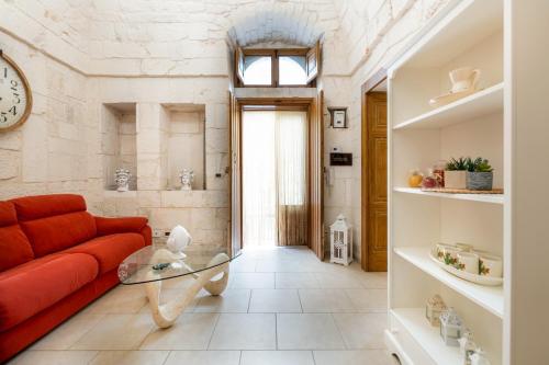 a living room with a red couch and a glass table at Casa Sea La Vie in Ostuni