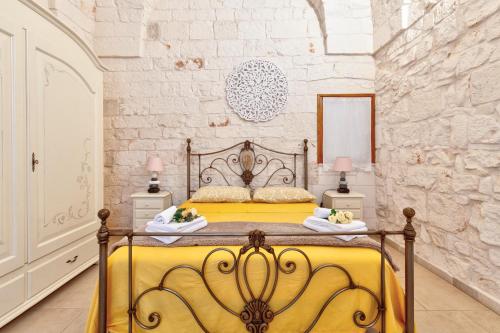 a bedroom with a yellow bed with two tables and two lamps at Casa Sea La Vie in Ostuni