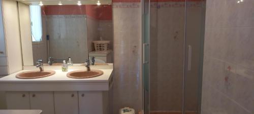 a bathroom with two sinks and a shower at Maison classée 2*, 6 personnes, animal accepté, mer 300m in Soulac-sur-Mer