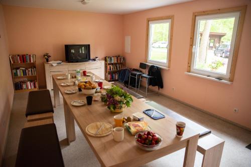una habitación con una mesa larga con fruta. en Knatter(ferien)häuschen, en Bantikow
