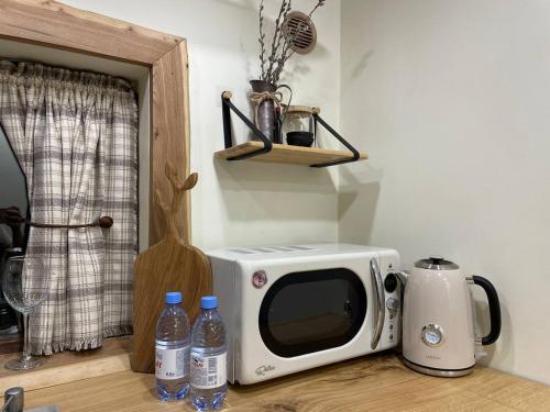 a microwave sitting on top of a counter with water bottles at SweeDom Shale in Almaty