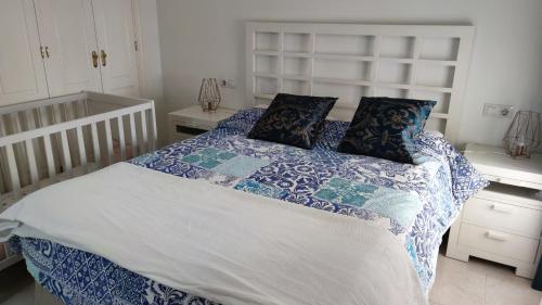 a bedroom with a bed with blue and white sheets and pillows at Tahona in Carmona