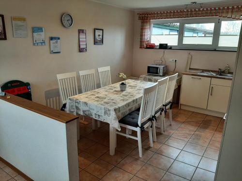 a kitchen with a table and chairs and a kitchen with a table and a microwave at Ferienhof Schräder "Ol Huus unnern" in Papenburg