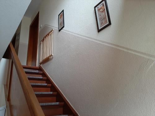 una escalera con dos cuadros en la pared y una escalera en Ferienhof Schräder "Ol Huus baben", en Papenburg