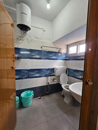 a bathroom with a toilet and a sink at Happy Home Stay in Ooty