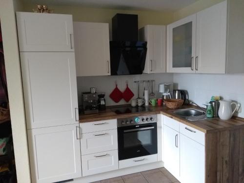 a kitchen with white cabinets and a stove top oven at Ostseeresidenz - Whg 14 in Zingst