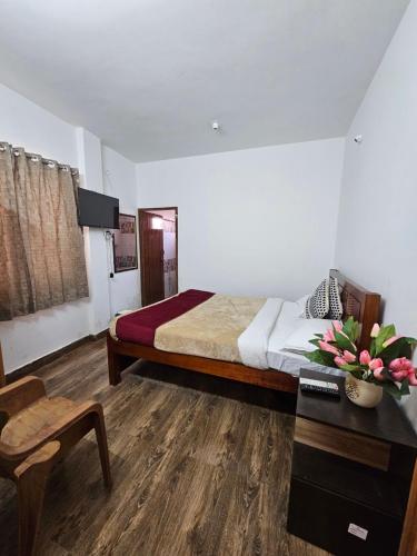 a bedroom with a bed and a desk and a chair at Happy Home Stay in Ooty