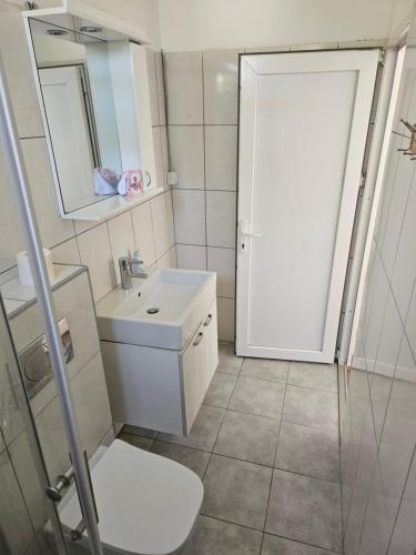 uma casa de banho com um lavatório branco e um espelho. em Apartments Kuca Aleksic em Niš