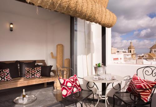 Habitación con sofá, mesa y ventana en Boutique Hotel Casa Cánovas en Cádiz