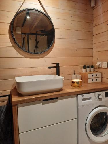 a bathroom with a sink and a washing machine at Domki Łomnicka Ostoja in Łomnica