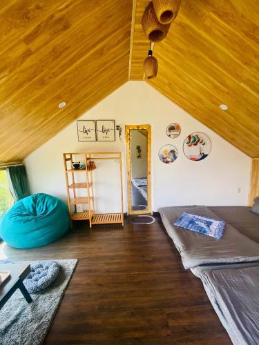 a room with two beds and a wooden ceiling at IZA Homestay in Trai Mat