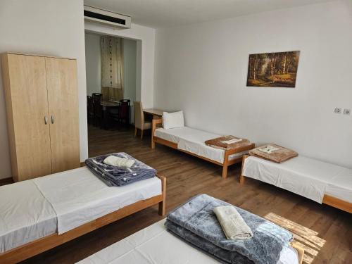 een kamer met drie bedden en een tafel bij Apartments Kuca Aleksic in Niš