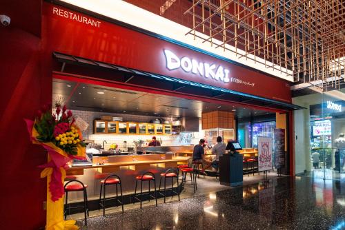 a restaurant with a bar and stools in a building at Bintang Collectionz Hotel in Kuala Lumpur