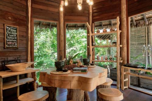 a room with a table and chairs and windows at Six Senses Yao Noi in Ko Yao Noi
