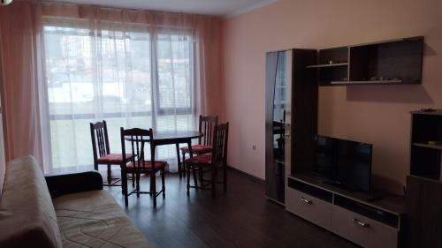 uma sala de estar com uma mesa e cadeiras e uma televisão em Apartment_Villa Astoria 3 em Elenite
