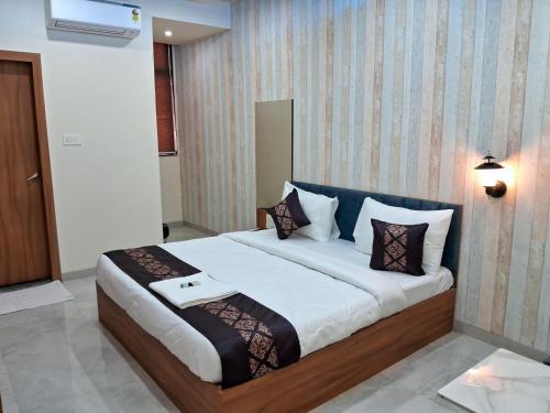 1 dormitorio con 1 cama grande con almohadas en Hotel The Marion, en Nashik