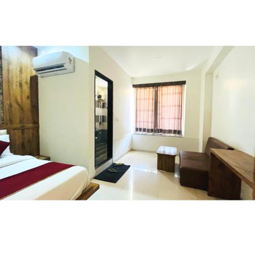 a bedroom with a bed and a couch and a window at hotel hill city in Gandhinagar