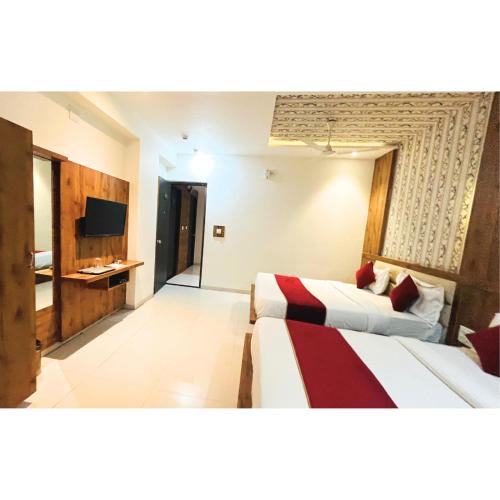 a hotel room with two beds and a television at hotel hill city in Gandhinagar