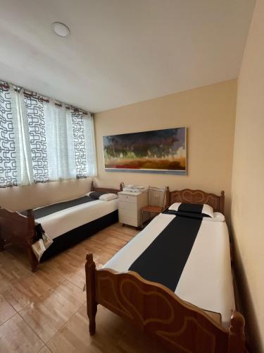 1 dormitorio con 2 camas y un cuadro en la pared en Hotel Kombinat en Tirana