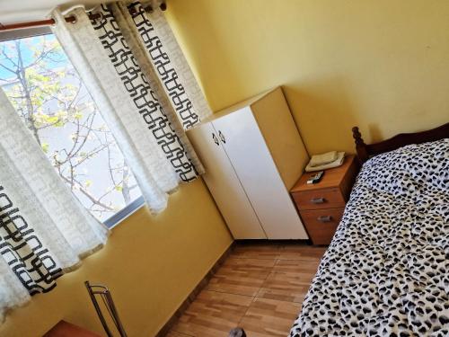 1 dormitorio con 1 cama, vestidor y ventana en Hotel Kombinat en Tirana