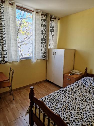 1 dormitorio con cama y ventana grande en Hotel Kombinat en Tirana