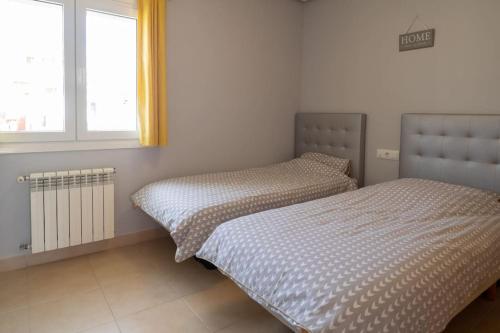 a bedroom with two beds and a window at Casa Gemela in Torre-Pacheco