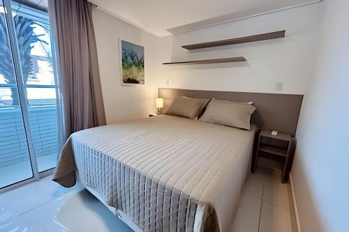 1 dormitorio con cama y ventana grande en Lindo Apto 2 quartos no Solar Tambaú en João Pessoa