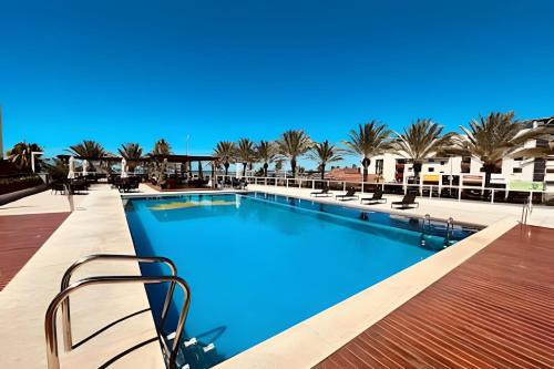 Lindo Apto 2 quartos no Solar Tambaú في جواو بيسوا: مسبح بالماء الأزرق والنخيل