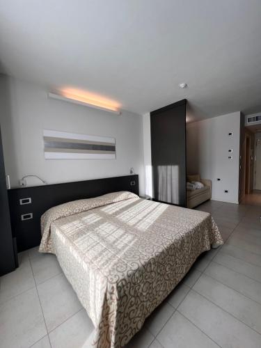 a bedroom with a bed with a blanket on it at Dante Family Beach Resort in Cervia