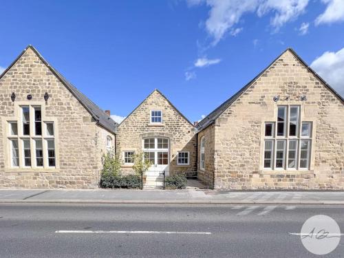 a large stone house with two large windows at Exceptional Holiday Home 5 with Hot Tub Pickering in Pickering