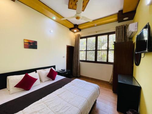 una camera da letto con un letto con cuscini rossi e una TV di Karachi Inn a Karachi