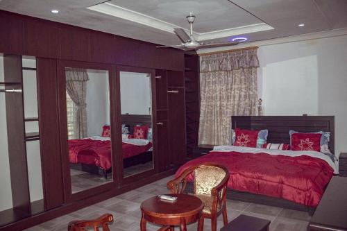 a bedroom with a red bed and a table and chairs at Luxe Isle by Harolty, East Legon in Accra