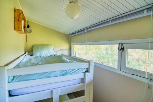 un lit dans une petite pièce avec une fenêtre dans l'établissement T3 - L'Atlantic Dream - 500m de la plage, à Seignosse