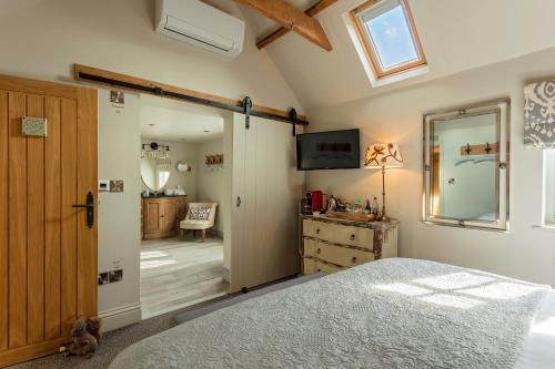 a bedroom with a bed and a desk and a window at Holly Lodge Boutique B&B in Thursford