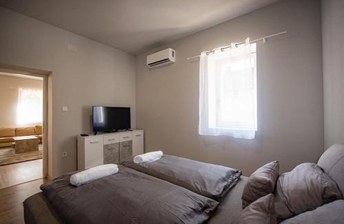 a living room with a couch and a tv at Hattyú Vendégház in Békésszentandrás