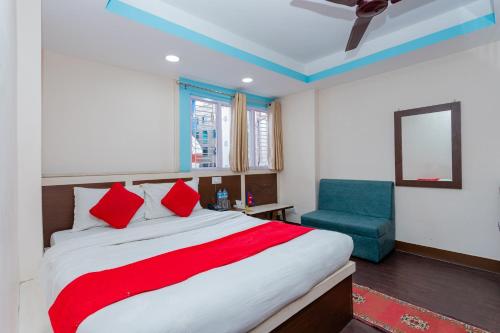 a bedroom with a bed and a blue chair at OYO 811 Hotel New Pokhara Palace in Kathmandu