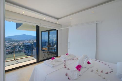 a white bedroom with a bed and a large window at Villa Sheyma in Kalkan