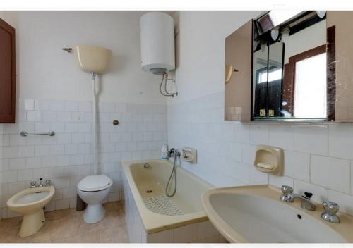 e bagno con servizi igienici, vasca e lavandino. di Casa vacanze Oristano Ghilarza Sardegna a Ghilarza