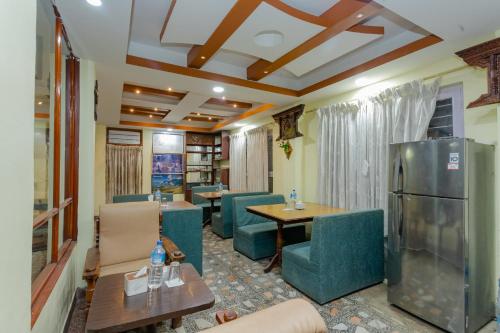 a room with chairs and tables and a refrigerator at OYO 811 Hotel New Pokhara Palace in Kathmandu