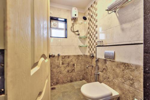 a bathroom with a toilet and a shower at Golden Sun Ray's Villas in Baga