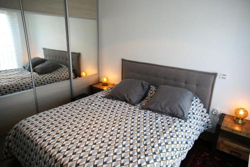 1 dormitorio con 2 camas y un espejo grande en LE COSY à Ensues la Redonne - Provence Conciergerie, en Ensuès-la-Redonne