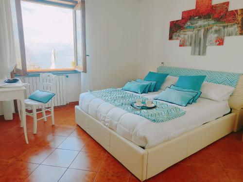 - une chambre avec un grand lit et des oreillers bleus dans l'établissement Camera Panoramica in Villa vista Mare e Vesuvio, à Massa Lubrense